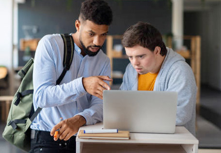 imagen de dos chicos mirando un ordenador, uno de ellos con discapacidad intelectual