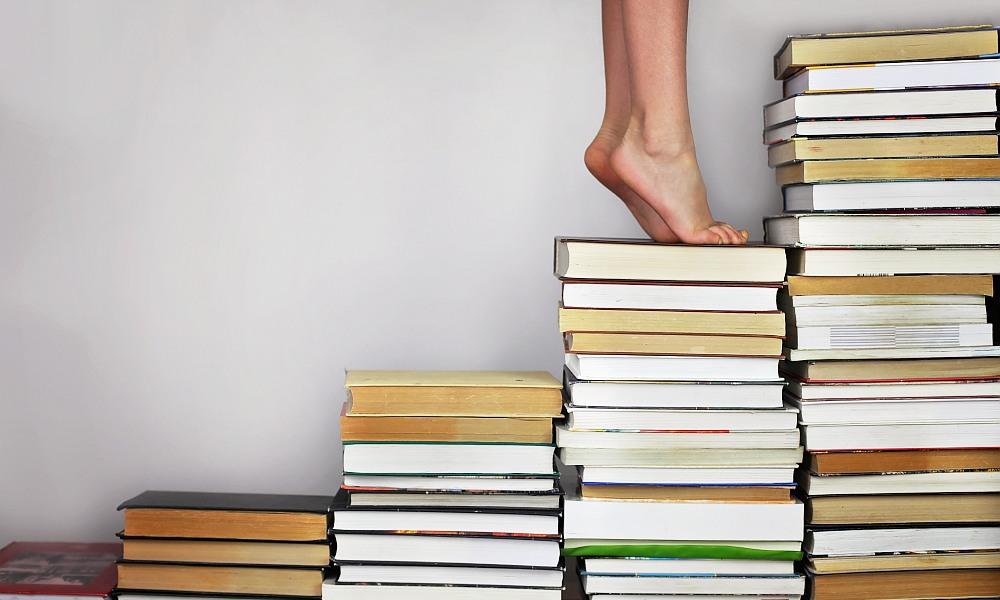 Escalera de libros con una persona subiendo